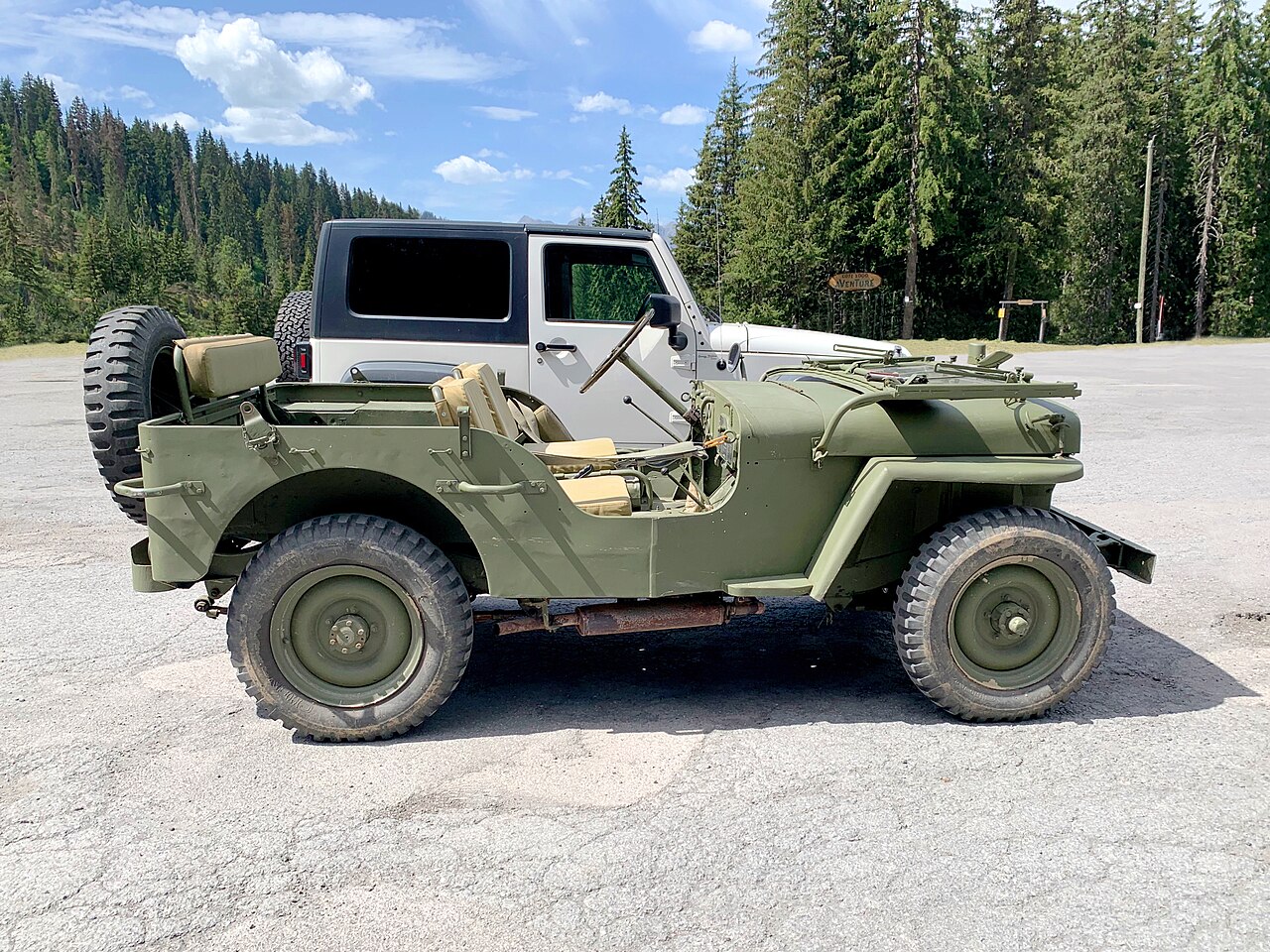 A WWII Willys MB parked beside a modern JK Wrangler